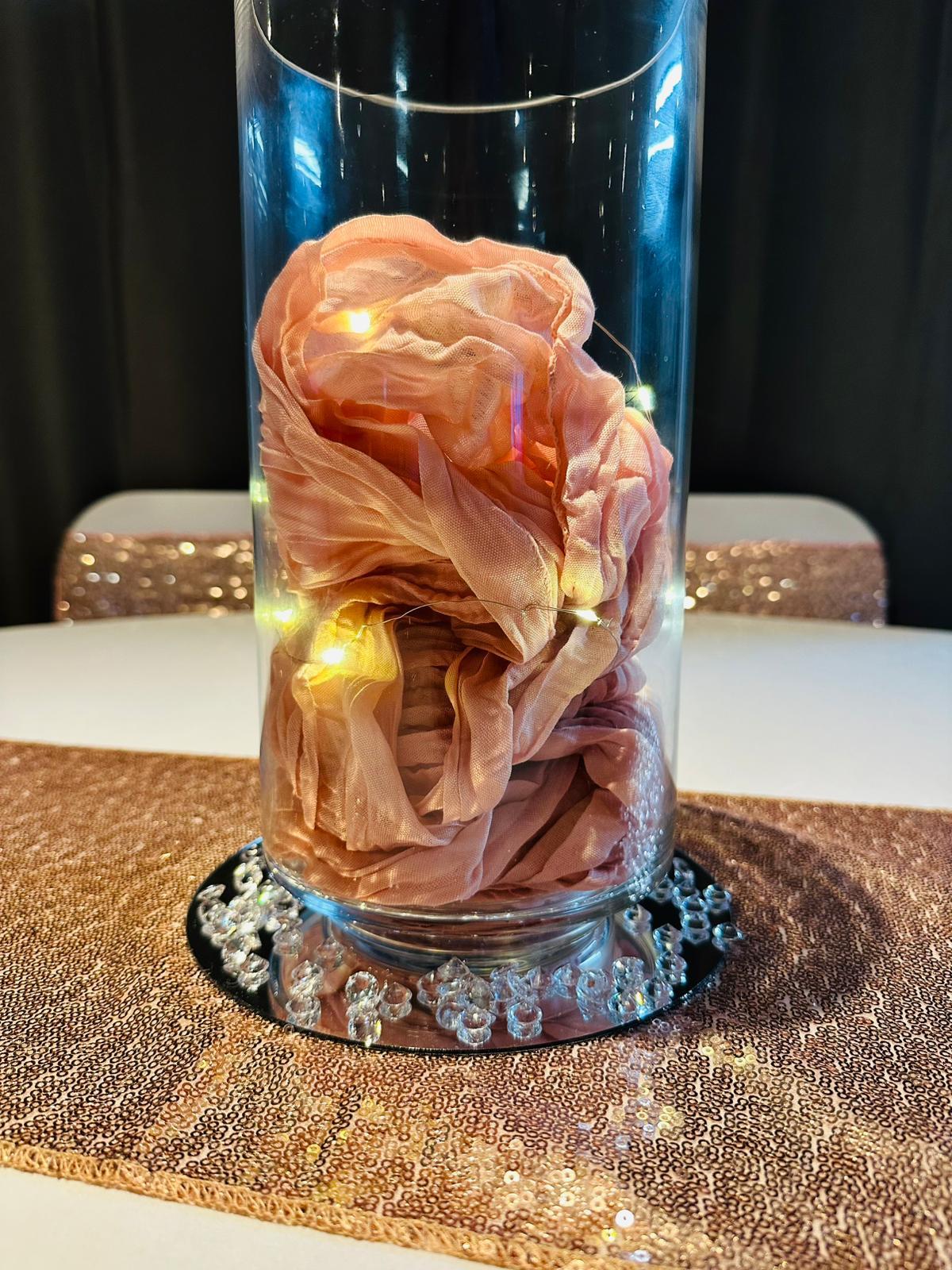 Lit table centrepiece with chiffon florals in a glass cylinder vase